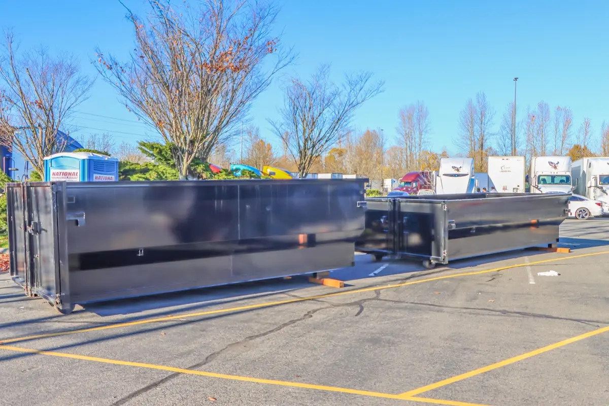 Professional dumpster rental service with roll-off container on residential driveway in West University Place